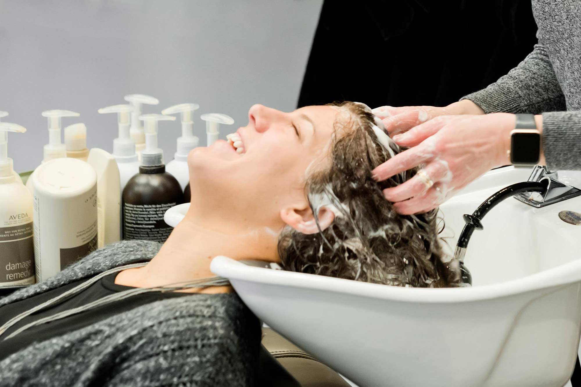 Cosmetologist washing client's hair