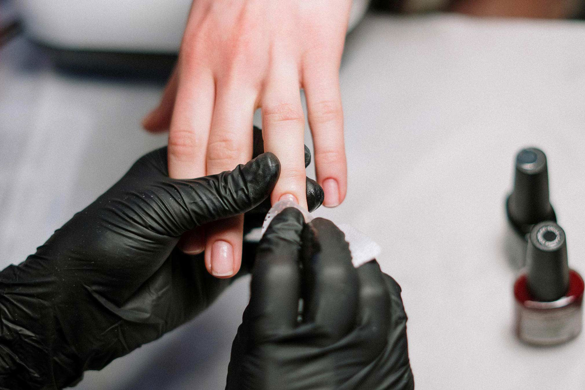 Cosmetologist working on client's nails