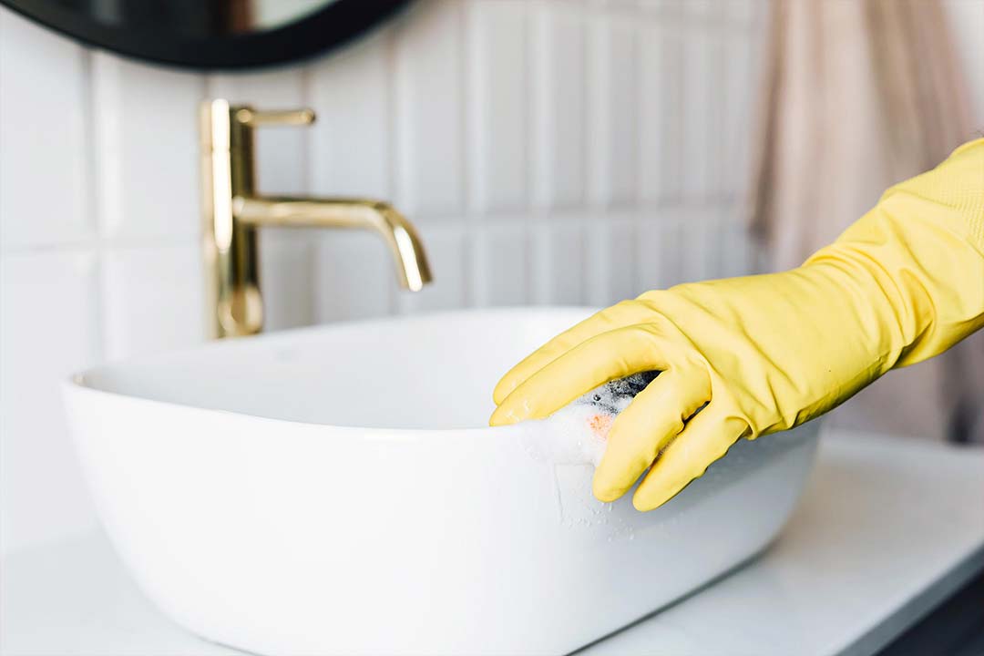 picture of a person using a sponge to clean a bathroom sink