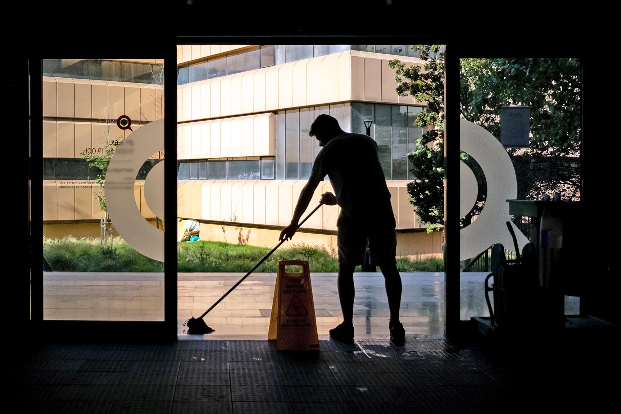 Janitor mopping floor in front of story entryway