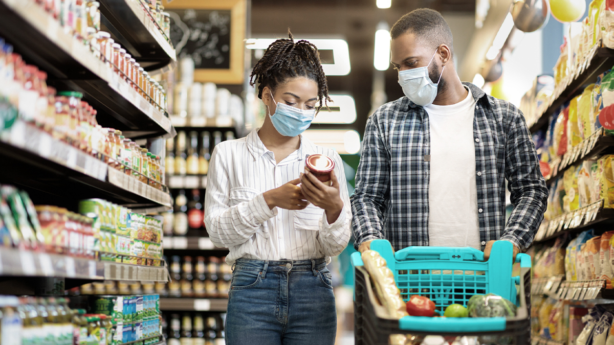 A couple compares products in a grocery store. Stores often require products to be insured by their manufacturers, wholesalers, distributors, or importers.