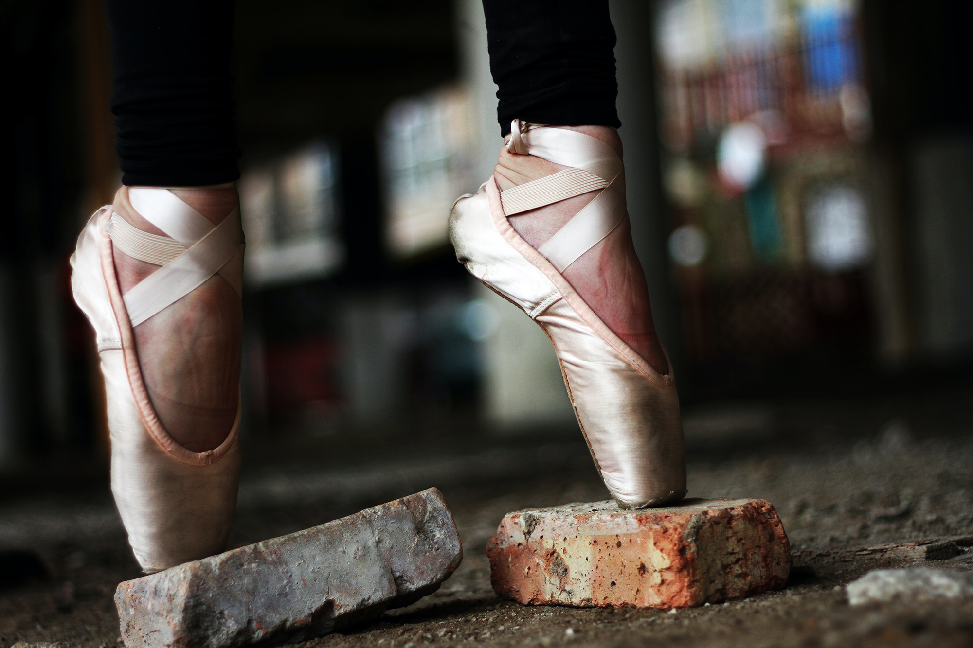 A dancer in point shoes stands on-point on bricks in the street. She could teach with confidence because she has Dance Instructor Insurance.