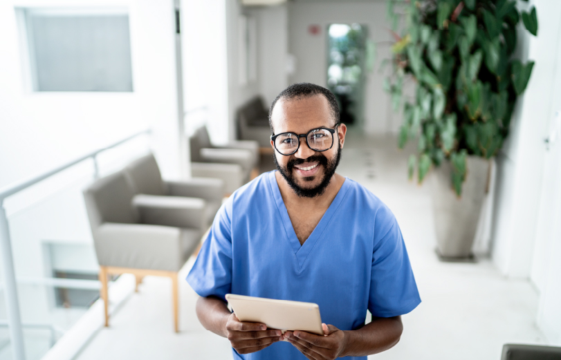 Image of a nurse in his scrubs smiling
