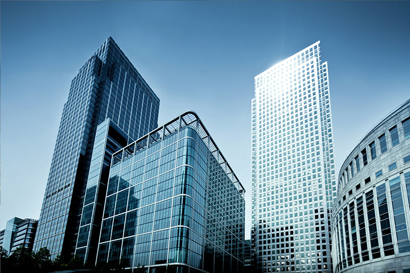 Large office buildings and skyscrapers stand tall under clear skies.